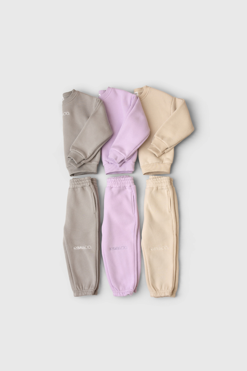 Remy & Co. embroidered kids crew tracksuit sets in Dark Grey, Lilac and Beige.