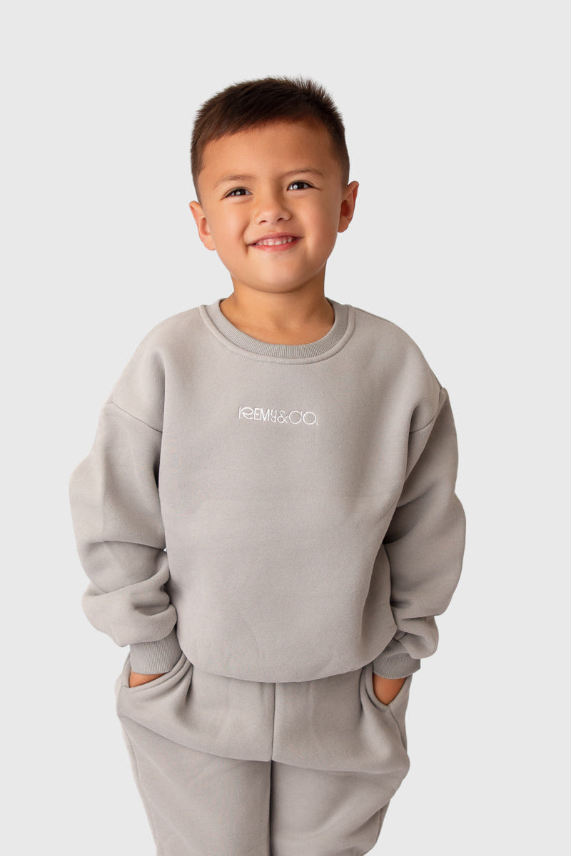 Child wearing the Remy & Co. Dark Grey embroidered crew tracksuit set.