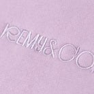 Close-up of the tonal embroidered Remy & Co. logo on Lilac fabric