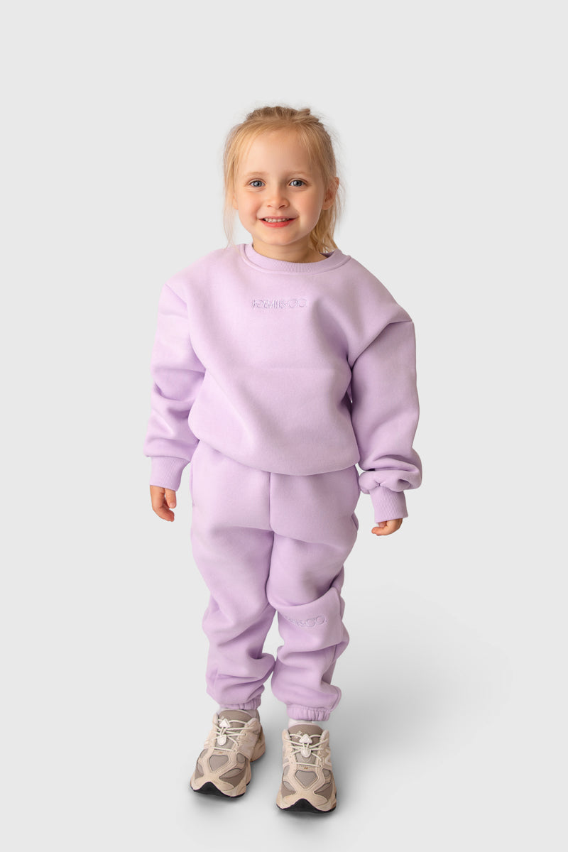 Child wearing the Remy & Co. Lilac crewneck sweatshirt and matching joggers on a white background