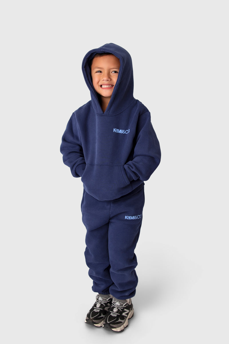 Child wearing the Remy & Co. Navy Blue Puff Print Hoodie Tracksuit Set.