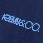Close-up of the Remy & Co. sky blue puff print logo on Navy Blue coloured fabric.