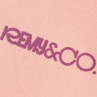 Close-up of the Remy & Co. puff print logo on Pink coloured fabric.